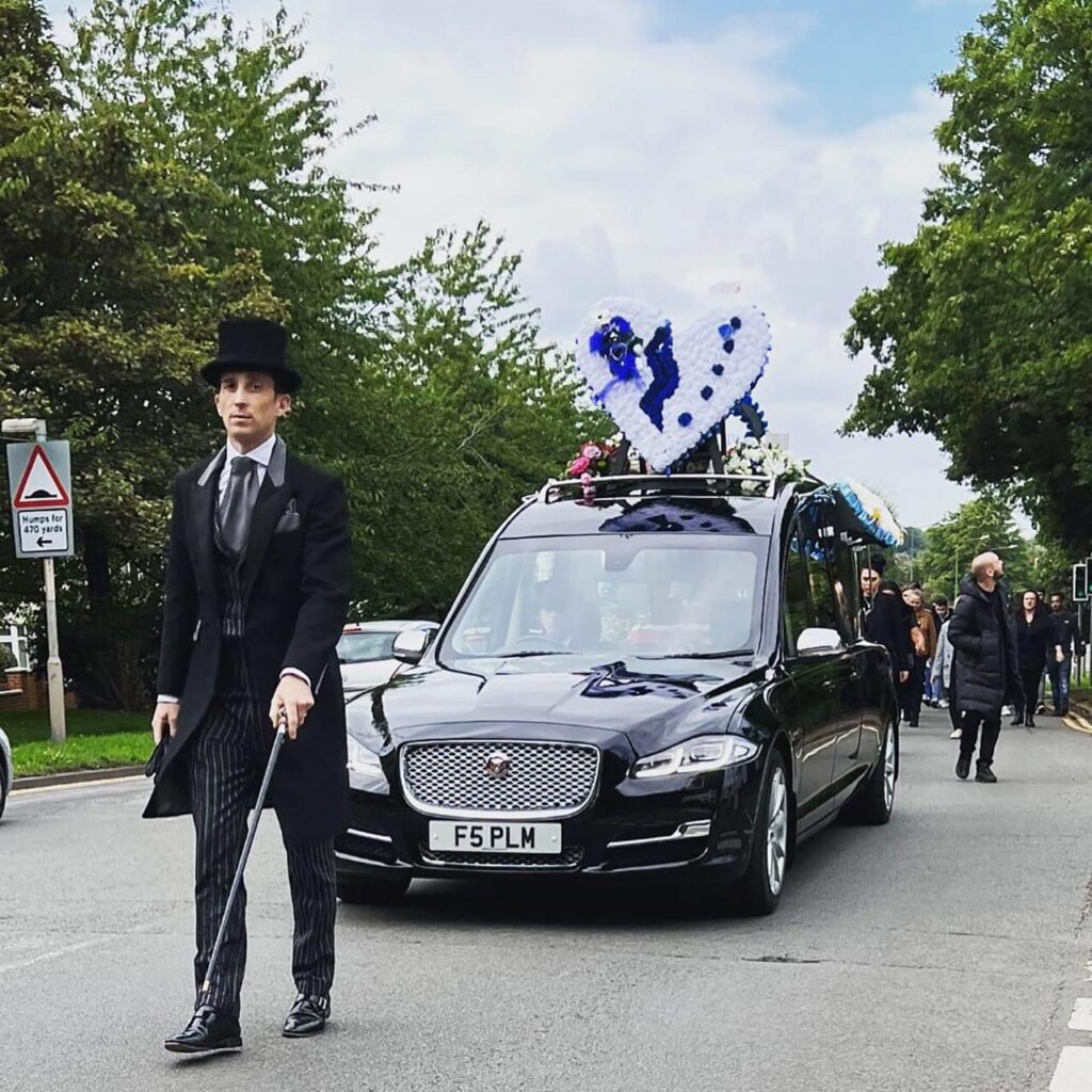 pl mulligan funeral hearse white flowers